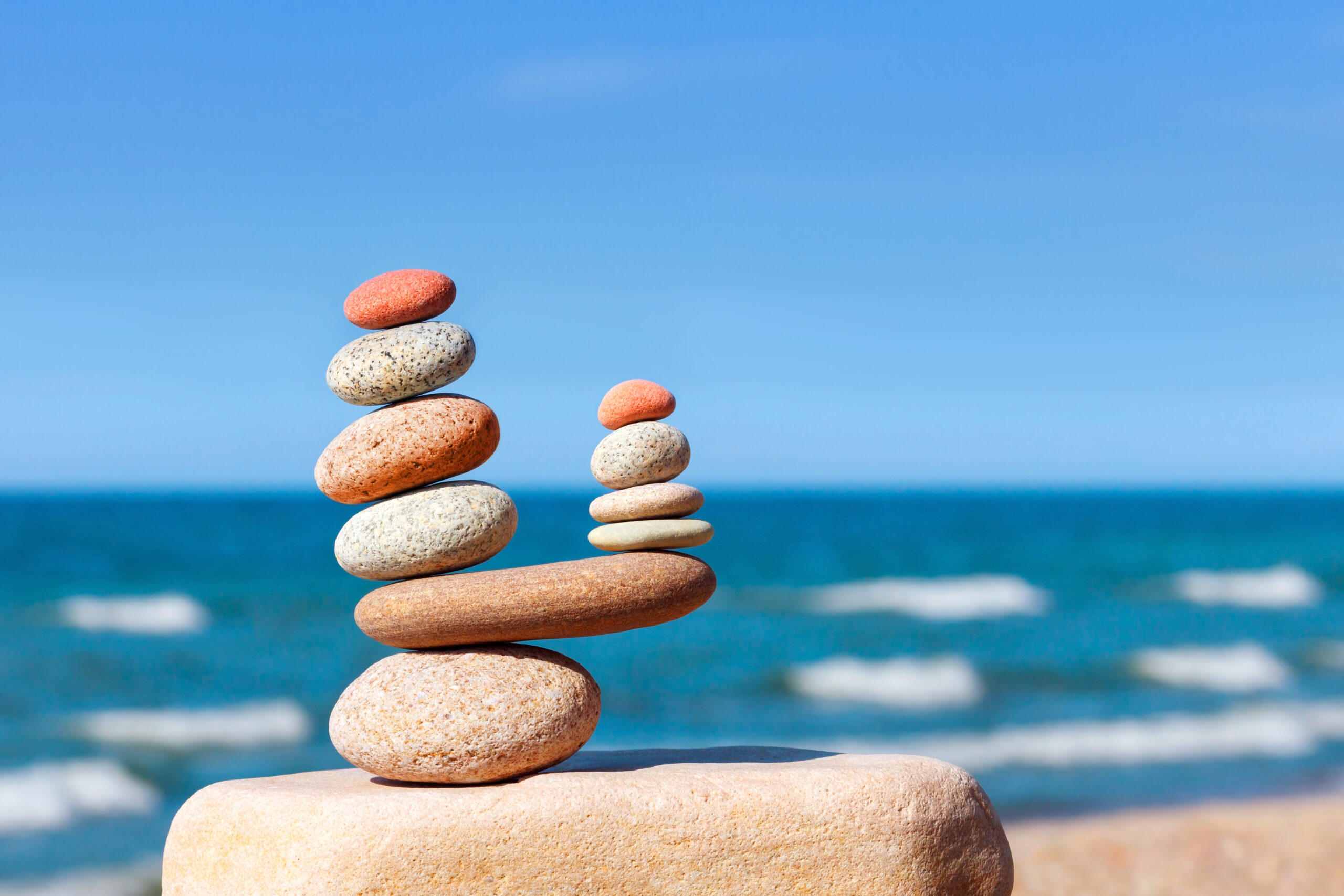 Stones balance on a background of blue sky and sea
